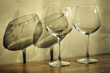 Wine glasses on a table with shadows