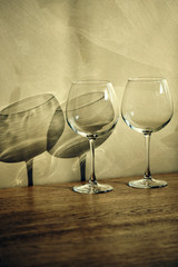 Wine glasses on a table with shadows (vertical)