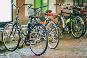 Fototapeta na wymiar Row Of City Parked Bicycles Bikes In European City In Night Time