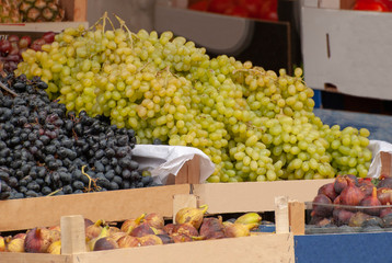 Grapes in a basket on the background of other fruits