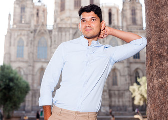 young European guy in blue shirt walking around city