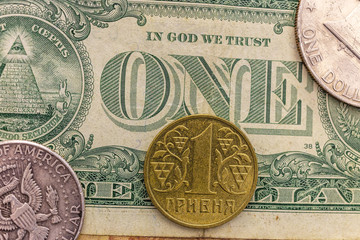 A 1 hryvnia coin lie on a one dollar bank bill