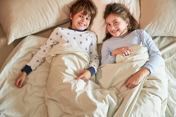 Bruder und Schwester liegen im Bett