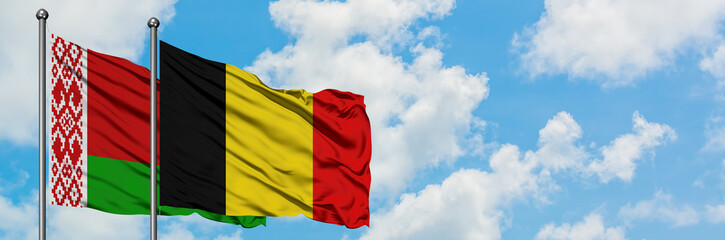 Belarus and Belgium flag waving in the wind against white cloudy blue sky together. Diplomacy concept, international relations.