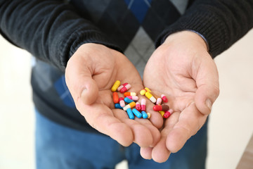 Elderly man with pills at home, closeup