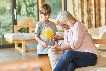 Enkelkind zeigt Oma sein Smartphone mit einer SMS