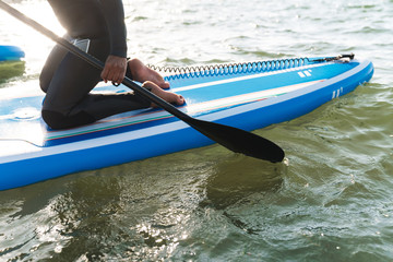 Cropped image of woman working out with stand up paddle board
