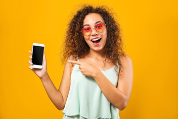 Portrait of happy African-American woman with mobile phone on color background