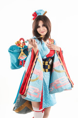 Beautiful leggy busty cosplayer girl wearing a stylized Japanese kimono costume cheerfully posing holding a fake pipe in the wind. Isolated on a white background.