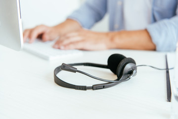 selective focus of black headset near operator in brokers agency typing in office