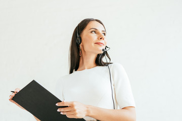 low angle view of broker in headset holding clipboard