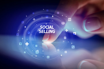 Finger touching tablet with social media icons and SOCIAL SELLING