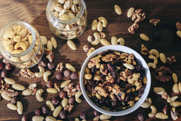 Fototapeta premium top view of a white bowl with varied organic nuts