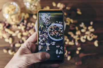 food blogger taking photo of varied dried fruits