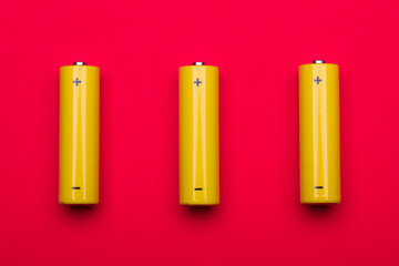 Yellow AA alkaline batteries on red background