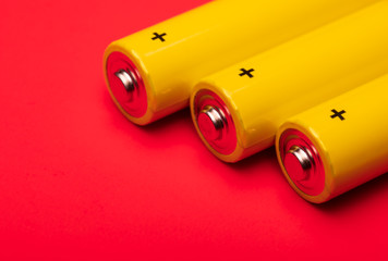 Yellow alkaline batteries on red background