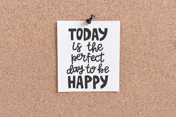 Quote card hanging on corkboard. Today is the perfect day to be happy