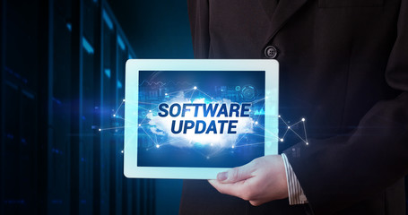 Young business person working on tablet and shows the inscription: SOFTWARE UPDATE