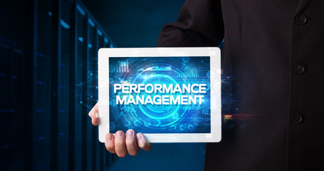 Young business person working on tablet and shows the inscription: PERFORMANCE MANAGEMENT, business concept