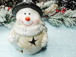 christmas snowman on fir tree branch with cones and snow on background