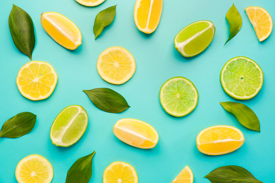 Ripe cut lemons and limes on color background