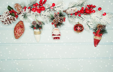 christmas fir tree branches with decorations on wooden background