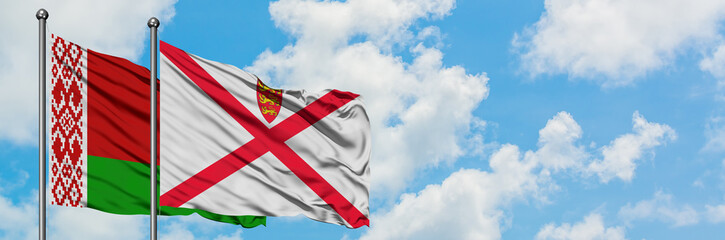 Belarus and Jersey flag waving in the wind against white cloudy blue sky together. Diplomacy concept, international relations.
