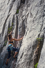 A girl climbs a rock.