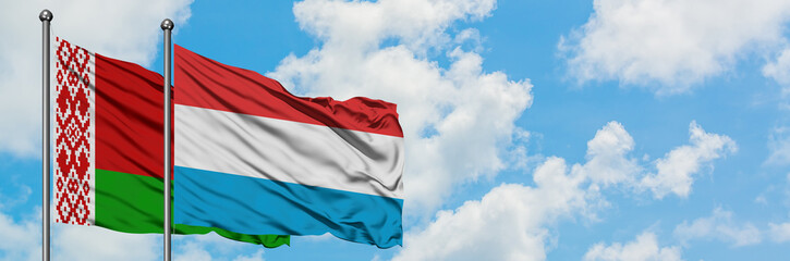 Fototapeta na wymiar Belarus and Luxembourg flag waving in the wind against white cloudy blue sky together. Diplomacy concept, international relations.