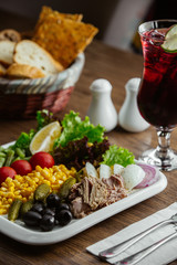 appitizers plate with olive, corn, boiled beef, lettuce, cornichon, tomato, lemon