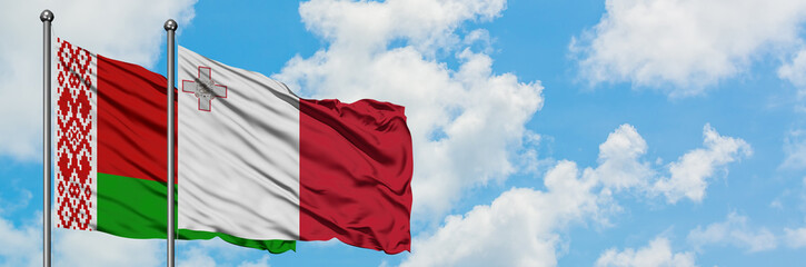 Belarus and Malta flag waving in the wind against white cloudy blue sky together. Diplomacy concept, international relations.