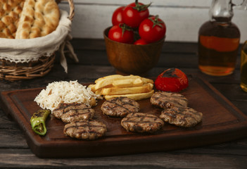 beef burger patties served with french fries, rice and grilled vegetables