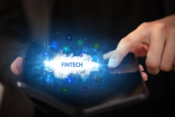Businessman holding a foldable smartphone with FINTECH inscription, technology concept