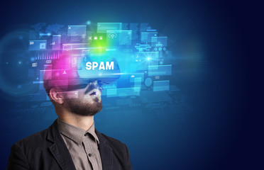 Businessman looking through Virtual Reality glasses with SPAM inscription, innovative security concept