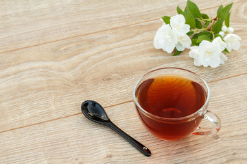 Glass cup of tea with white jasmine flowers.