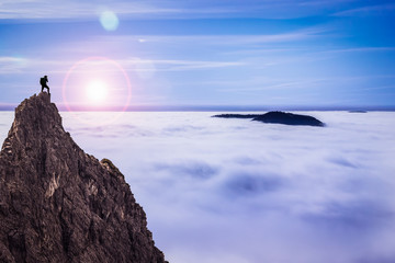 Hiker on top of a Mountain Looking to the Sunrise