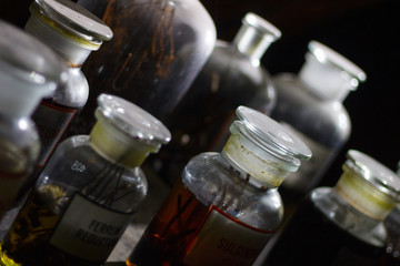 Set of alchemy bottles in laboratory of alchemist. Herb in old pots with dust on  the glass surface.Alchemy symbol and objects. Poison and elixir in glass jar. Set of vessel, ampulla, flask,drink.....
