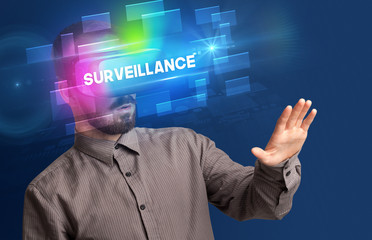 Businessman looking through Virtual Reality glasses with SURVEILLANCE inscription, innovative security concept