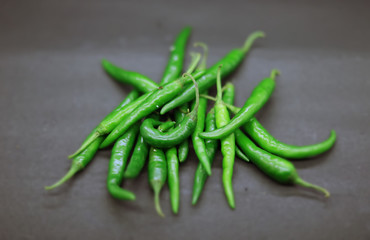 Fresh green chilli on black background. Top view
