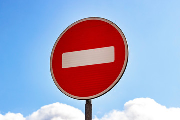 Red and white Do not enter sign on blue sky background.