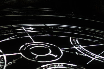  Black floor with alchemy symbol.  Mysterious scheme on dark background. Mystery signs of hermetic art. Witchcraft, devilry, necromancy, diablerie, diabolism, devilment, sorcery, wizardry, witchery. 