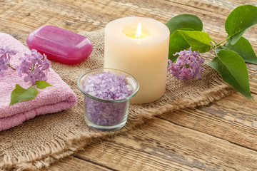 Obraz na płótnie Canvas Towel, soap and lilac flowers on wooden background.