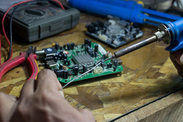 Technicians use a soldering iron and lead to repair electronic circuits.