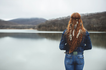 Long-haired girl on lake shore
