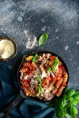 Fusilli pasta with tuna in tomato sauce. Top view with copy space.