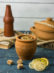 clay pot next to dried lemon slices and brown sugar cubes