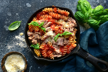 Fusilli pasta with tuna in tomato sauce. Top view with copy space.