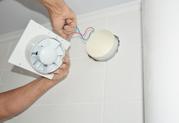 Fototapeta Handyman installing new bath vent fan, ventilation system in the house bathroom . Bath fan repair, installation. obraz