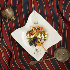 fresh vegetables salad with white cheese, herbs and lemon