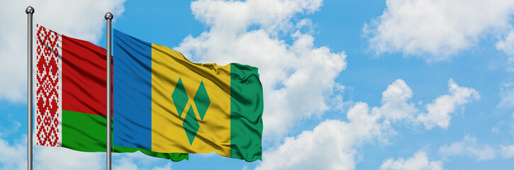 Belarus and Saint Vincent And The Grenadines flag waving in the wind against white cloudy blue sky together. Diplomacy concept, international relations.